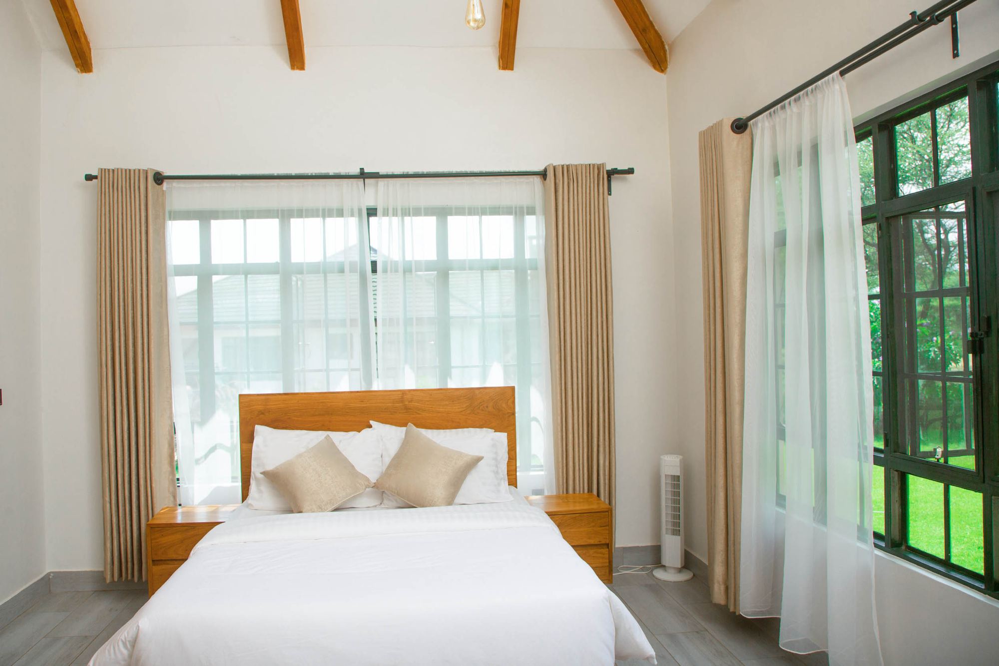 Double bedroom with a timber bed and tall garden windows