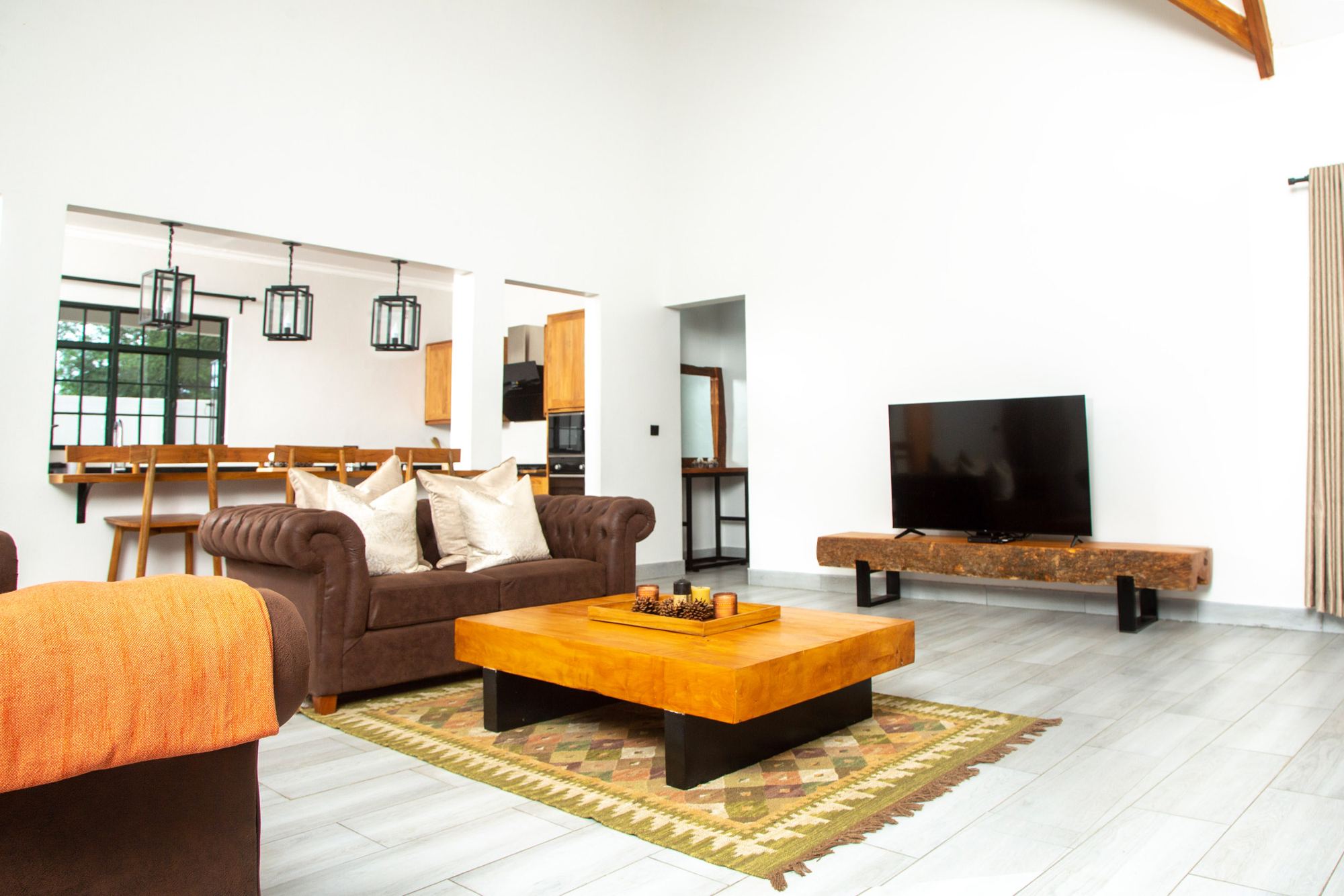 Living room with leather sofas under a timber-beamed ceiling