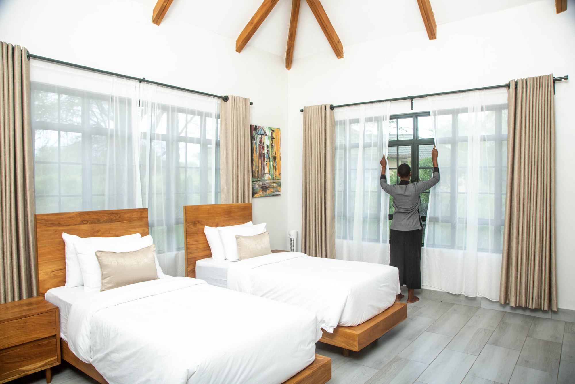 Twin bedroom with two timber beds and tall windows